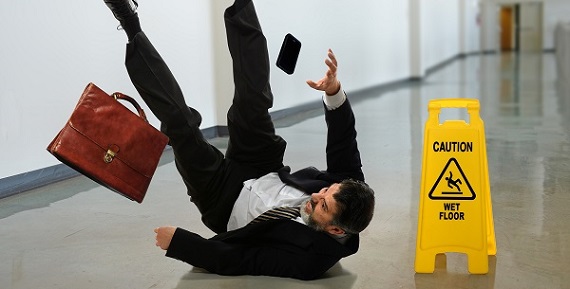 Senior businessman falling near caution sign in hallway